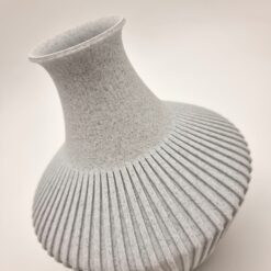 Rifliuota vaza sausoms gėlėms iš arti – matoma tekstūra ir medžiagos struktūra.